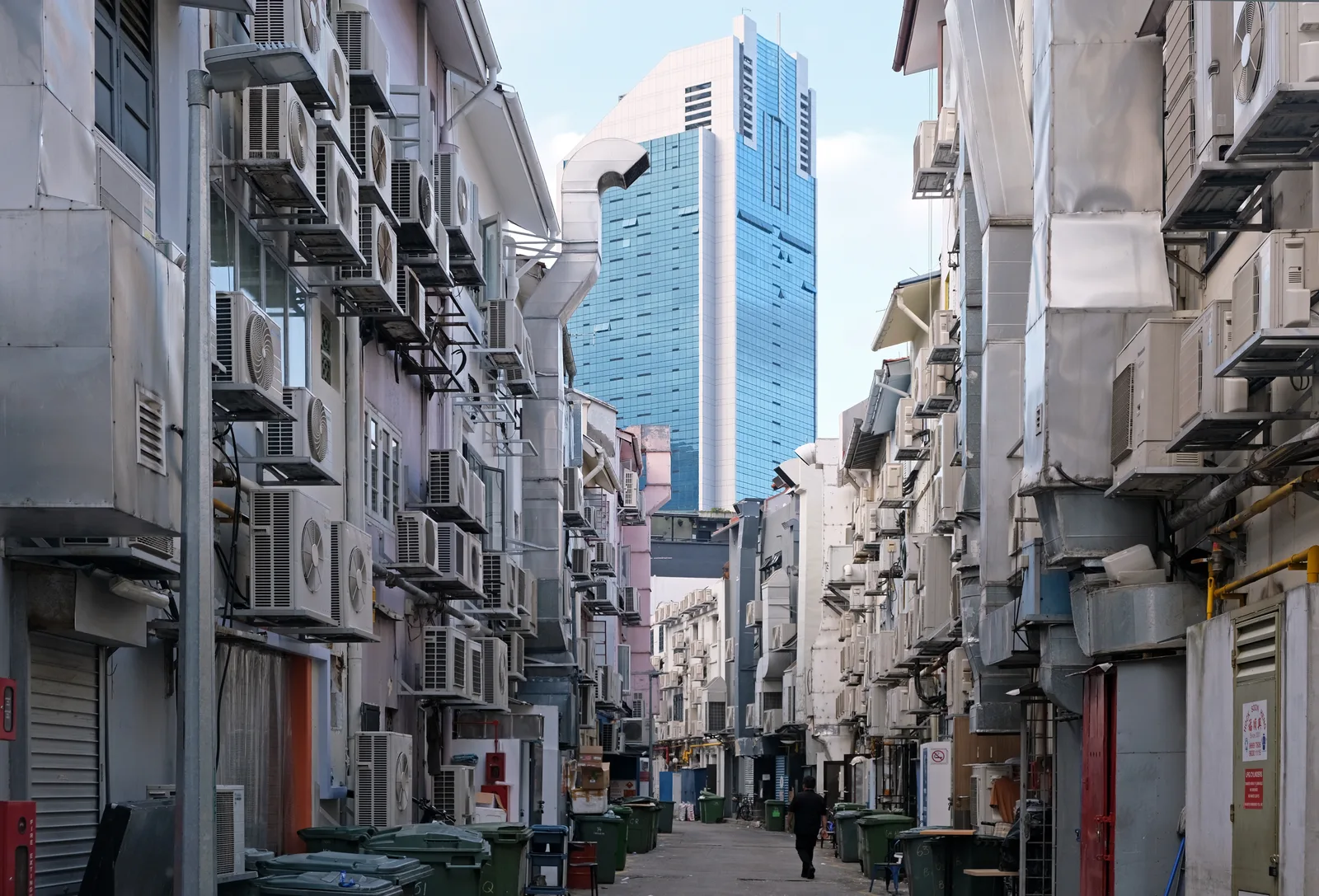 Ruelle étroite derrière Boat Quay à Singapour, dont les façades sont entièrement couvertes de groupes extérieurs de climatisation empilés.